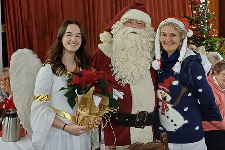 Der Nikolaus mit seinem Engelchen und ein Mitglied mit weihnachtlichen Pullover