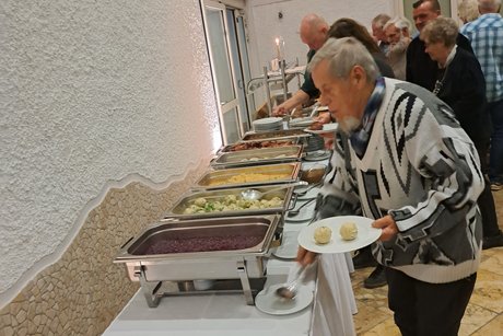 Buffet Mitglieder stehen an und bedienen sich am reichhaltigem Buffet