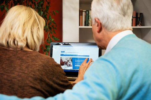 Ein &auml;lteres Paar am Computer, auf dem Bildschirm sieht man die Facebook-Seite des VdK Deutschland