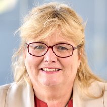 L&auml;chelnde junge Dame mit blondem Haar und Brille