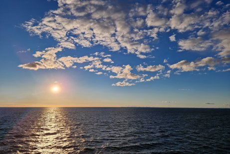 Die Sonne spiegelt sich golden auf ruhiger See
