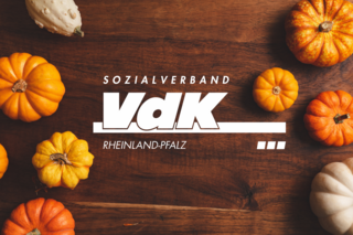 Das herbstliche Bild zeigt das VdK Logo inmitteln von Kürbissen