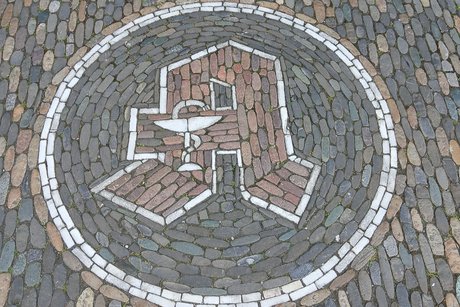 Freiburger Zunftwappen der Apotheker. Ein großes A im Kreis.