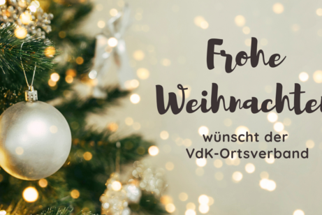 Weihnachtskugel an einem Tannenbaum und der Schriftzug: Frohe Weihnachten.