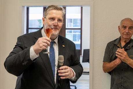 Kreisvorsitzender Schaumann Zu sehen ist auf dem Bild der Kreisvorsitzende Heinz-Wilhelm Schaumann mit einem Sektglas in der Hand, der den Anwesenden zu prostet.