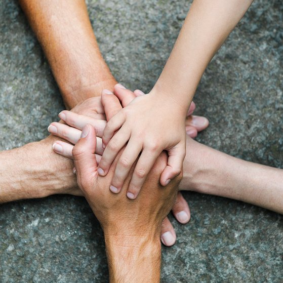 F&uuml;nf Personen legen jeweils eine Hand aufeinander, so dass ein Kreis bzw. ein Stern entsteht