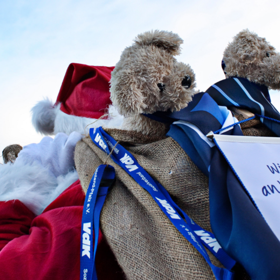 Weihnachtmann mit Jutesack, aus dem ein VdK-Wimpel schaut.
