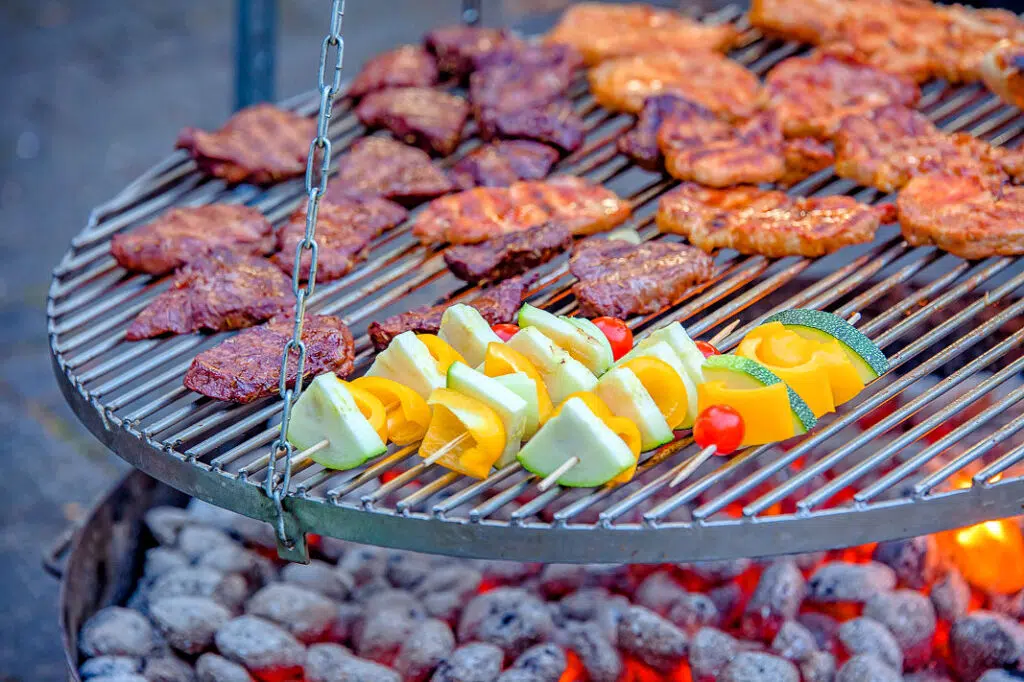 Schwenkgrill mit Steaks und Spießen