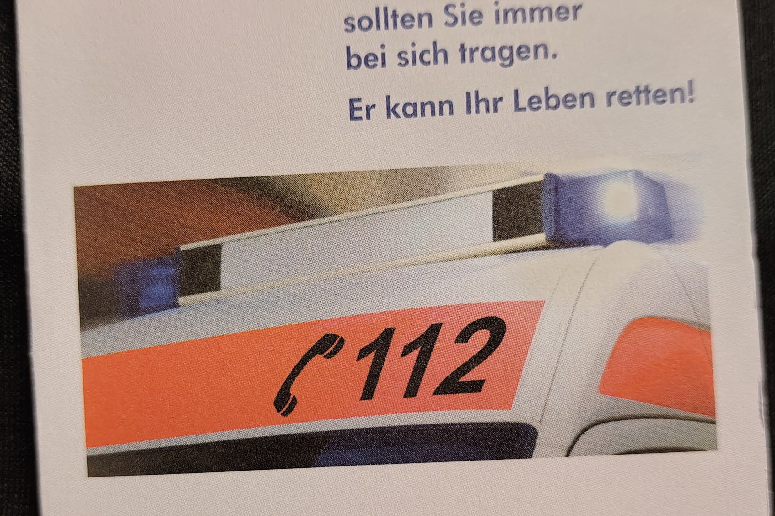 Der Notfallausweis wird von vorne gezeigt mit VdK-Logo und einem Bild von einem Ausschnitt eines Rettungswagen.