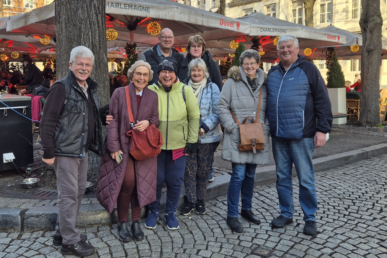 Mitglieder die mitgefahren sind vor einen Weihnachtsmarktstand.