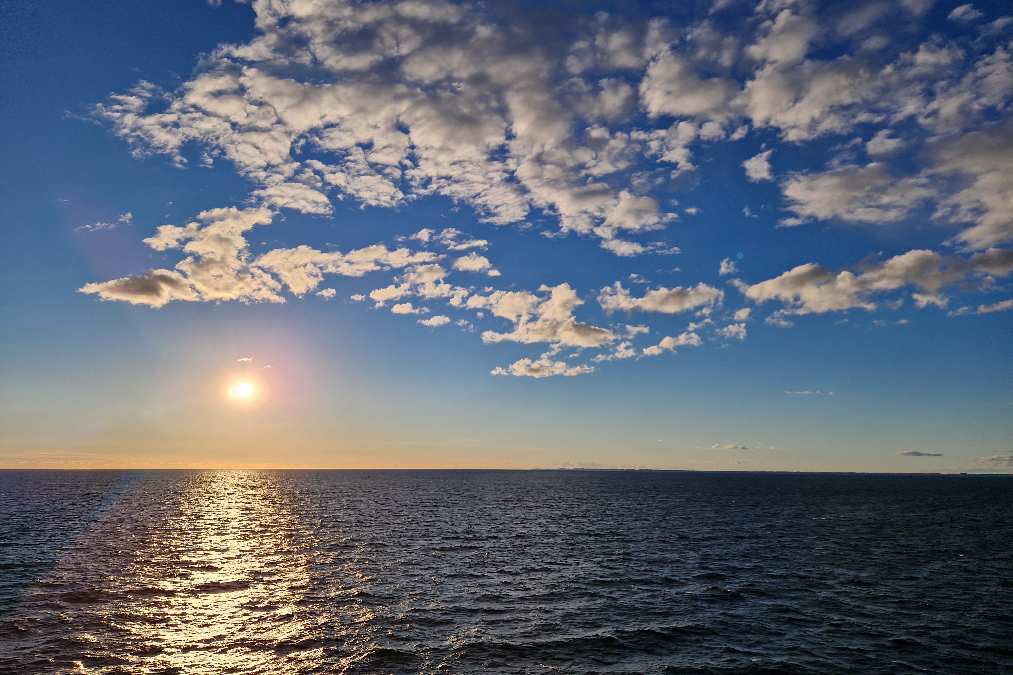 Die Sonne spiegelt sich golden auf ruhiger See
